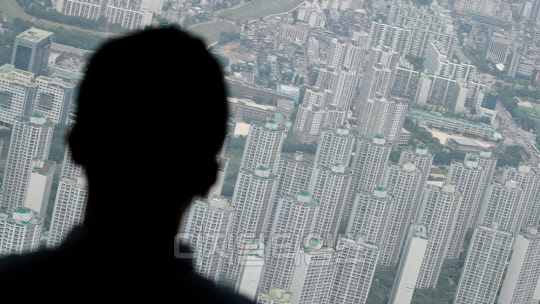 정부와 여당이 적극 추진하는 임대차 3법이 전세 시장을 안정시킬지 관심이 모아진다. 한 시민이 송파구 일대 아파트 단지를 바라보고 있다.  연합뉴스